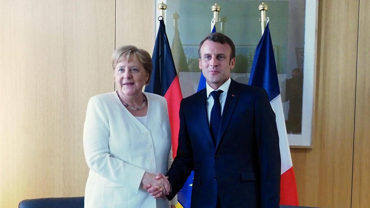 Den tyska förbundskanslern Angela Merkel och den franske presidenten Emmanuel Macron skakar hand pre-corona. Arkivbild.