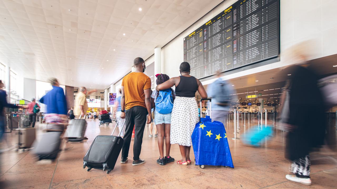 Semesterfirare står vid en flygplats