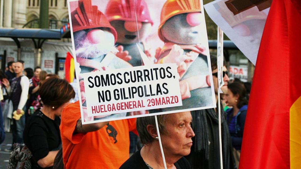 "Vi som arbetar är inga idioter" står det på plakatet som den spanska demonstranten håller i. Arkivbild.