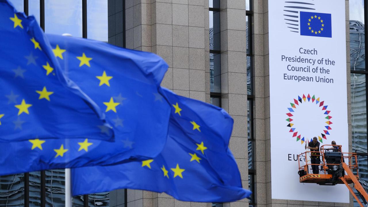 Det tjeckiska ordförandeskapets banderoll monteras upp på rådsbyggnaden i Bryssel. 