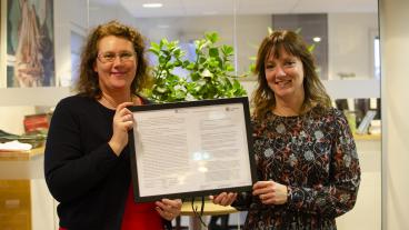 Kristina Bergman Alme (L) och Marina Johansson (S) visar upp dokumentet som visar att Göteborg lovat jobba med utbildning och livslångt lärande inom ramen för det sociala protokollet.